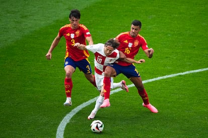 Luka Modric se lleva el balón entre Rodri y Le Normand.