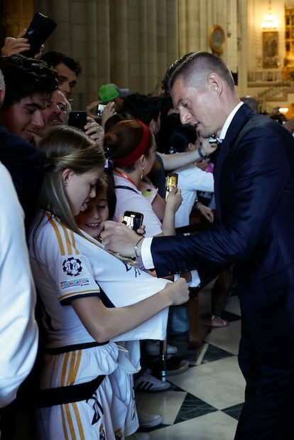 El centrocampista del Real Madrid Toni Kroos firma camisetas a aficionados en la Catedral de la Almudena.
