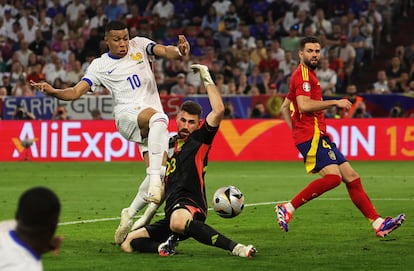 El guardameta español Unai Simón corta una acción de Kylian Mbappé.