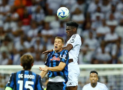 Mario Pasalic del Atalanta salta de cabeza por un balón, con Tchouameni, del Real MAdrid.