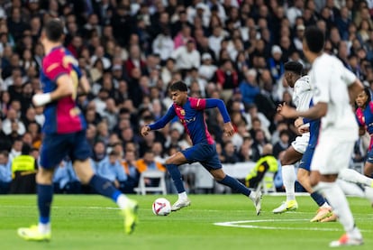 Lamine Yamal controla el balón perseguido por varios jugadores del Real Madrid.