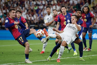 El defensa del Real Madrid Lucas Vázquez, pelea un balón con el centrocampista del Barcelona Marc Casadó.
